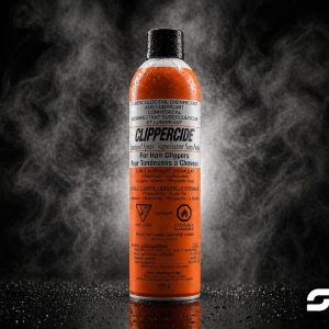 Orange ClipperCide disinfectant spray for hair clippers, black cap, on a reflective surface with a smoky dark background; brand logo bottom right.
